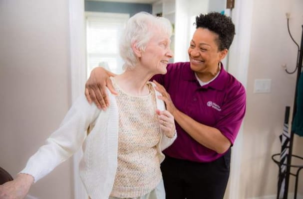 Caregiver assisting a resident with a smile
