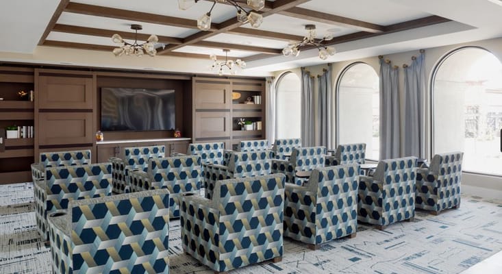 A common area with colorful patterned chairs and a TV