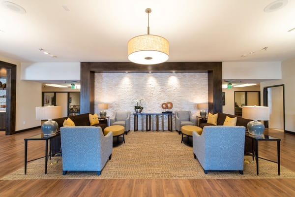 Cozy living room area with grey and yellow chairs and decorative lighting