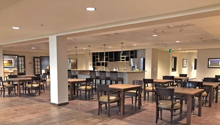 Spacious dining area with wooden tables and chairs.