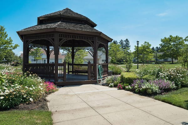 Outdoor gazebo surrounded by flowers and greenery