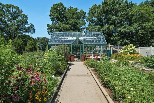 Garden area with a greenhouse surrounded by flowers
