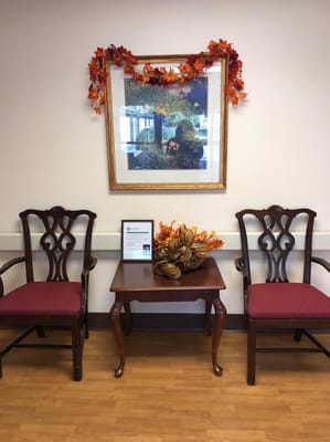 Cozy lobby with chairs, a table, and autumn decorations.