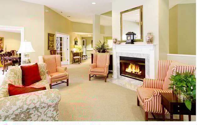 Warm living room with striped chairs and a fireplace