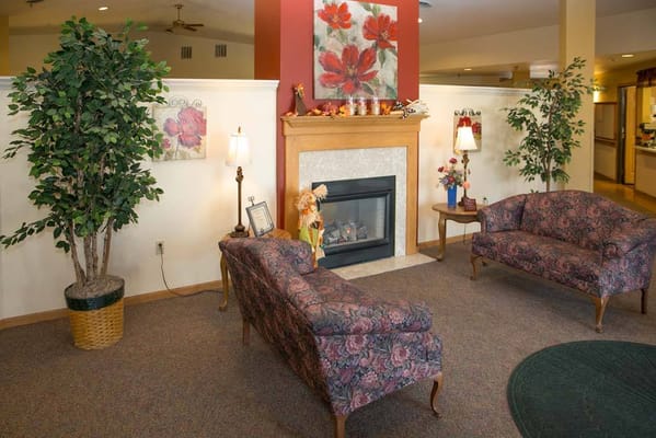 Cozy living room with floral couches and fireplace