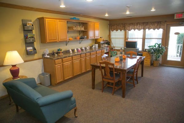 A cozy common area with a kitchen counter, dining table, and lounge seating.