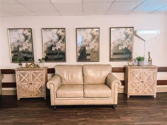 Lounge area with a beige couch and framed artwork on the wall