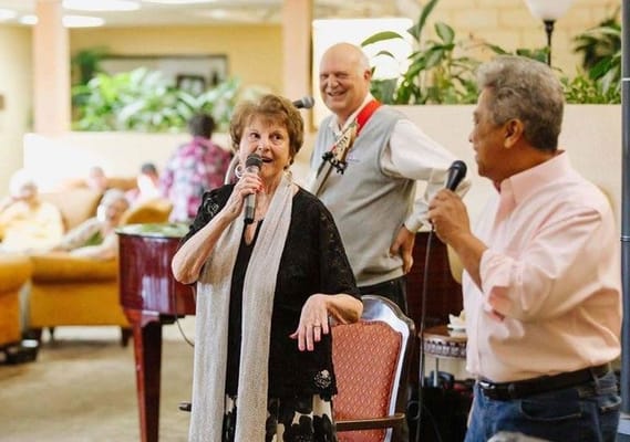 Residents and staff enjoying a musical performance in a lounge