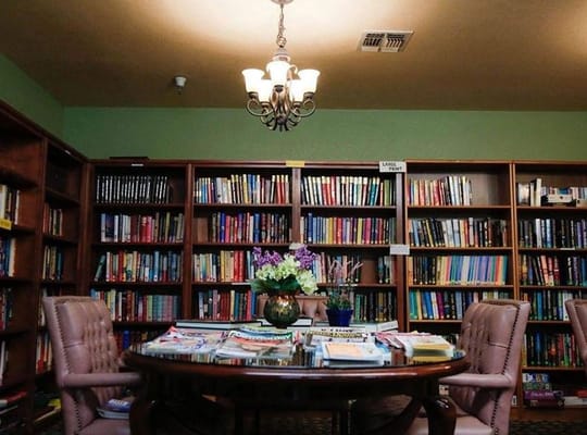 Interior of a cozy library with bookshelves and a table