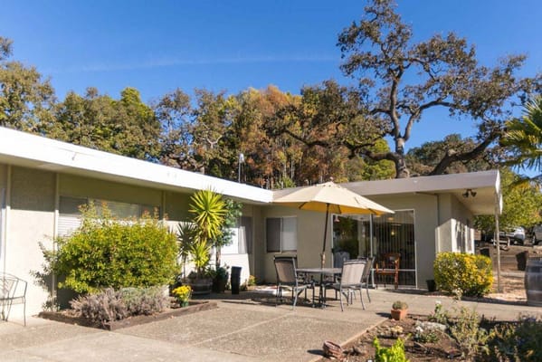 A sunny patio with tables and umbrellas at Summerfield Healthcare Center
