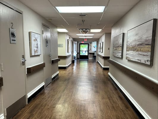 Well-lit hallway with artwork on the walls