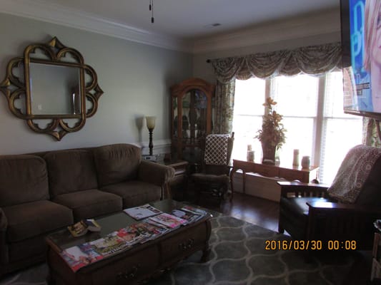 A cozy living room with a sofa, coffee table, and large window.