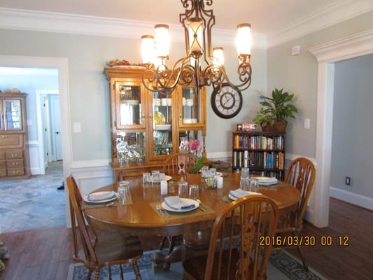 Wooden dining table set for a meal with a chandelier above.