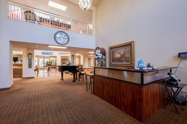 Welcoming lobby with piano and reception desk at Truewood by Merrill - Roseville