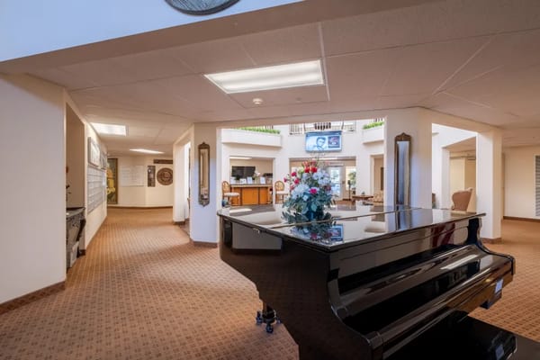 Black piano with floral arrangement in the lobby area