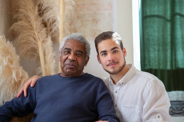 Senior man sitting with a young man in a cozy indoor setting
