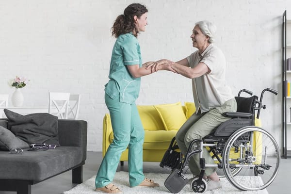 A caregiver assisting an elderly woman in a wheelchair