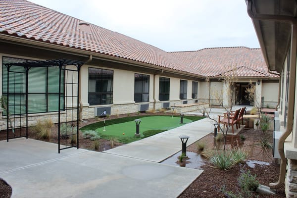 Outdoor courtyard area with artificial grass and seating