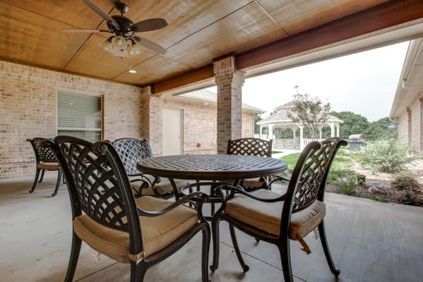 Table and chairs on a patio overlooking a garden area