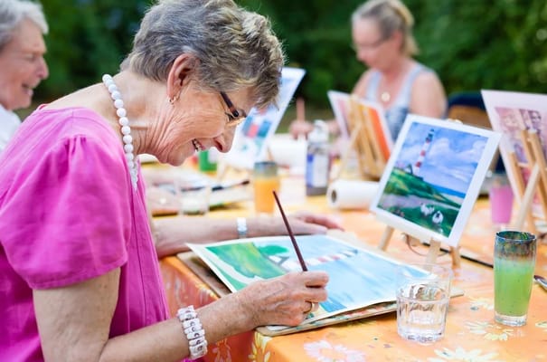Residents enjoying a painting activity outdoors