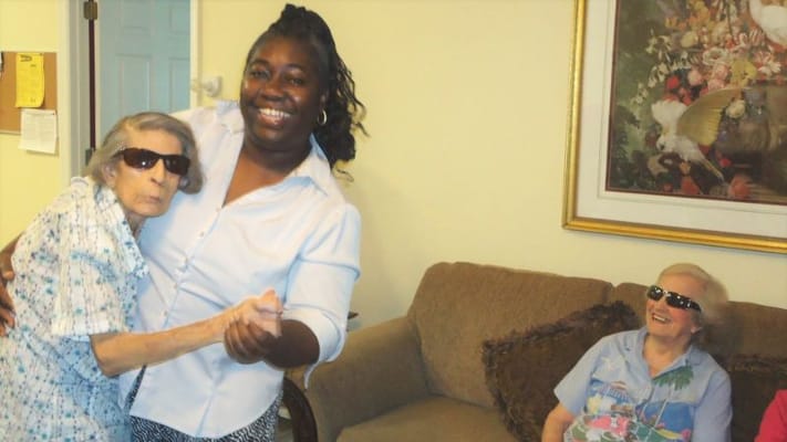 Residents enjoying a dance with staff inside the facility