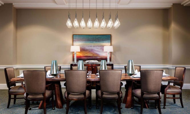 Elegant dining room with a large wooden table and hanging lights