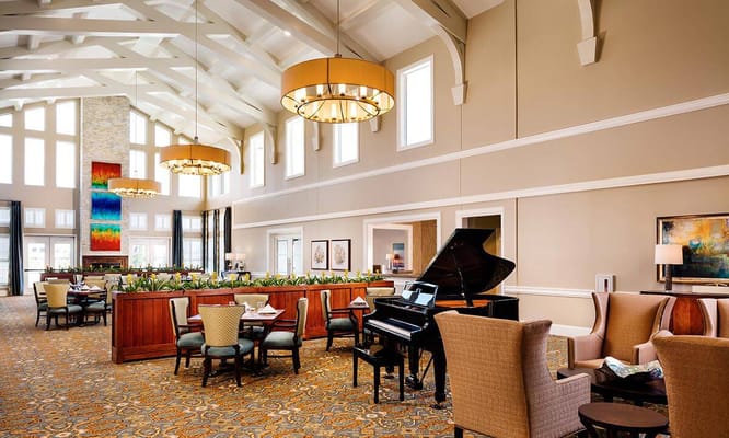 Bright and inviting common area with seating and a piano