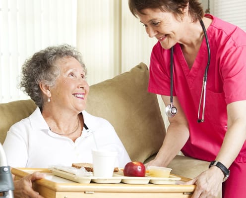 Caregiver serving food to a senior resident
