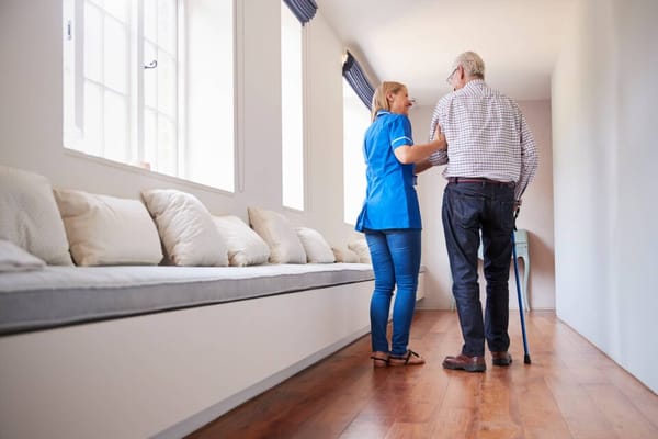 Staff member assisting a resident in a hallway