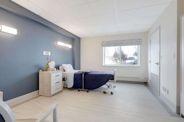 Bright bedroom with a bed, dresser, and window at Southview Acres.