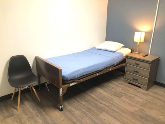 Private resident room with a bed and bedside lamp