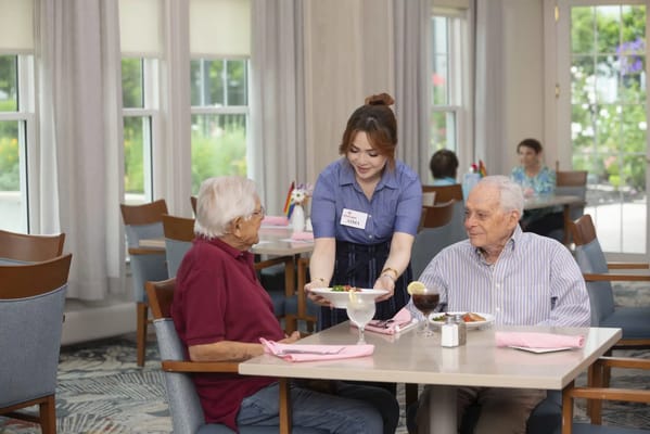 Staff serving residents in a dining area