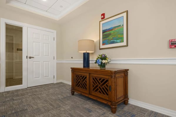 Bright interior hallway with a cabinet and artwork