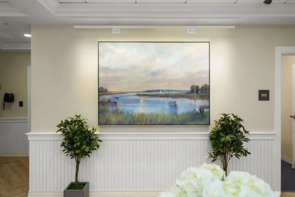 A calm painting of a lakeside view in a facility interior