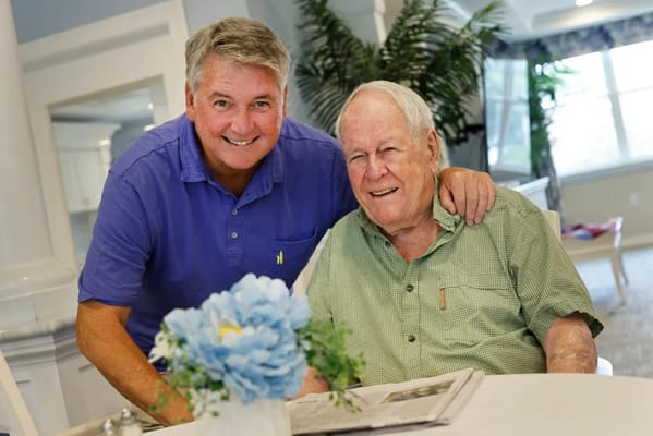 Resident and staff member smiling together in a common area