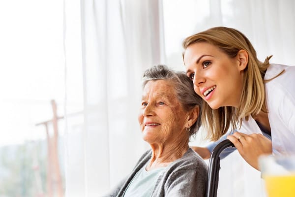 Caregiver talking to a smiling resident