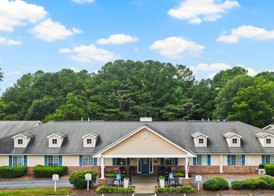 Exterior view of a senior living facility surrounded by trees