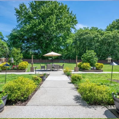 Pathway leading to outdoor seating area with greenery
