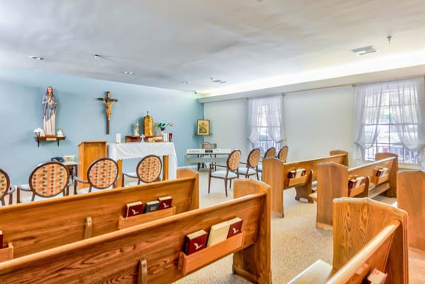 Interior view of a chapel with wooden pews and altar