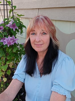 Woman sitting near flowering plants in a garden