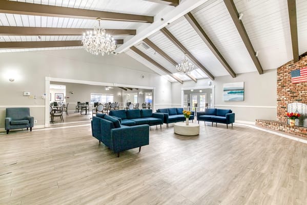 Bright common area with blue couches and chandeliers