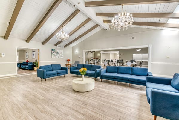 Bright common area with blue seating and chandeliers