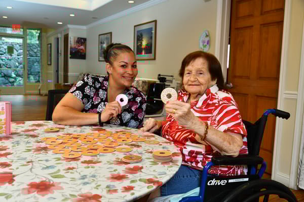 Staff member and resident playing a game indoors