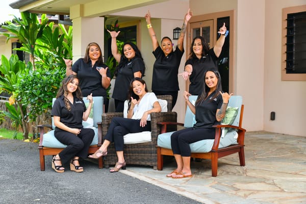 Staff members posing cheerfully in an outdoor area