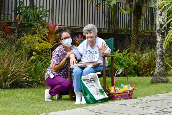 Resident and staff member in a garden setting