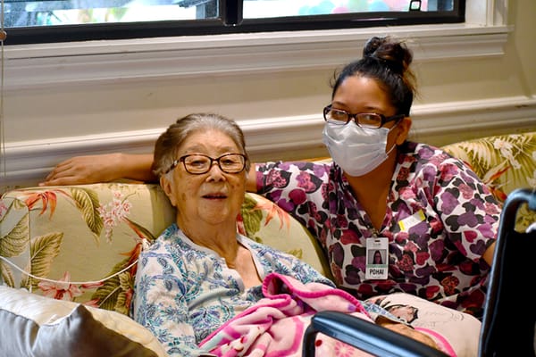Resident and staff member sitting together on a couch