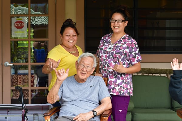 Residents and staff posing happily outdoors