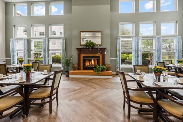 Dining area with tables set for meals and a fireplace