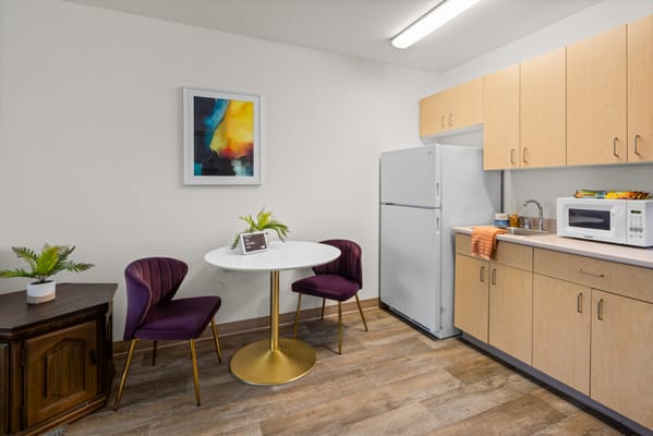 Bright kitchenette area with modern furniture and art