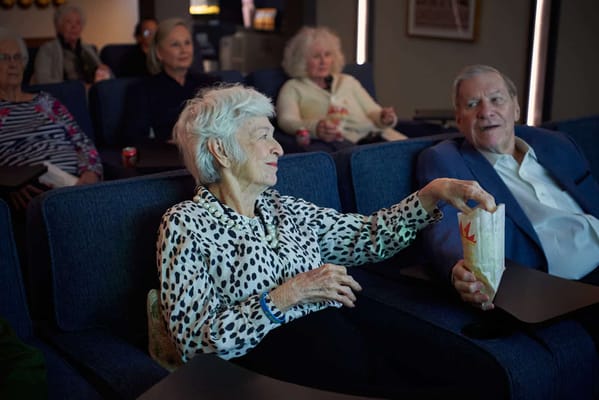 Residents enjoying a movie in a cozy theater room